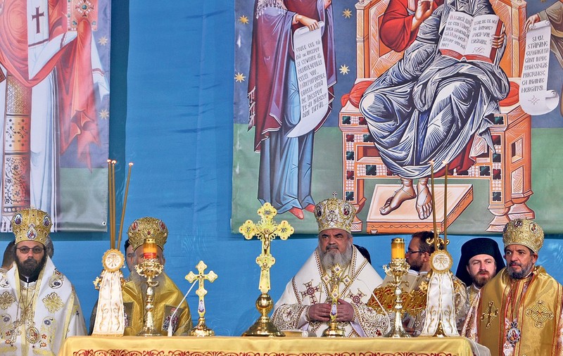 Preoţii, sub umbrare, credincioşii, copţi la soare
