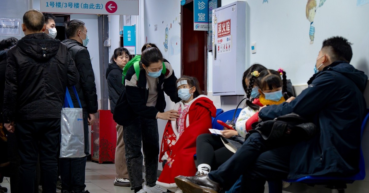Pacienți care poartă mască, între ei și copii, așteaptă în fața unui cabinet medical dintr-un spital din China
