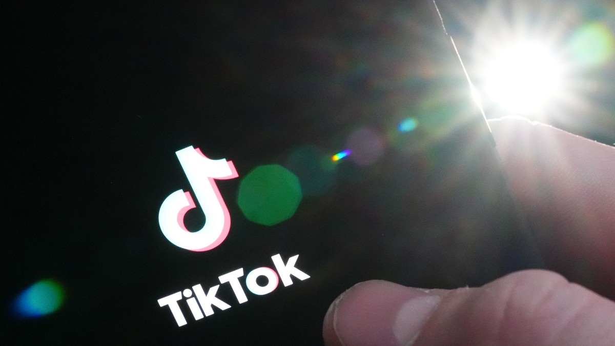 Ecranul unui telefon smart și un deget pe inscripția TIkTok