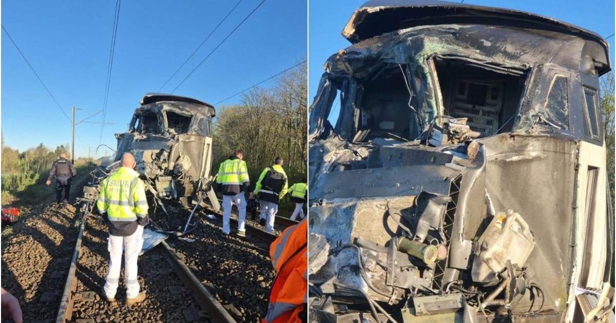 Un camion grav avariat se află pe calea ferată după impact, cu partea frontală complet distrusă. În jur, echipele de intervenție analizează locul accidentului și evaluează pagubele produse.