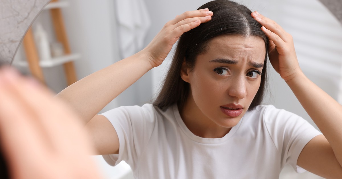 70 Femeie emoțională care își examinează părul și scalpul acasă. Problemă cu mătreața