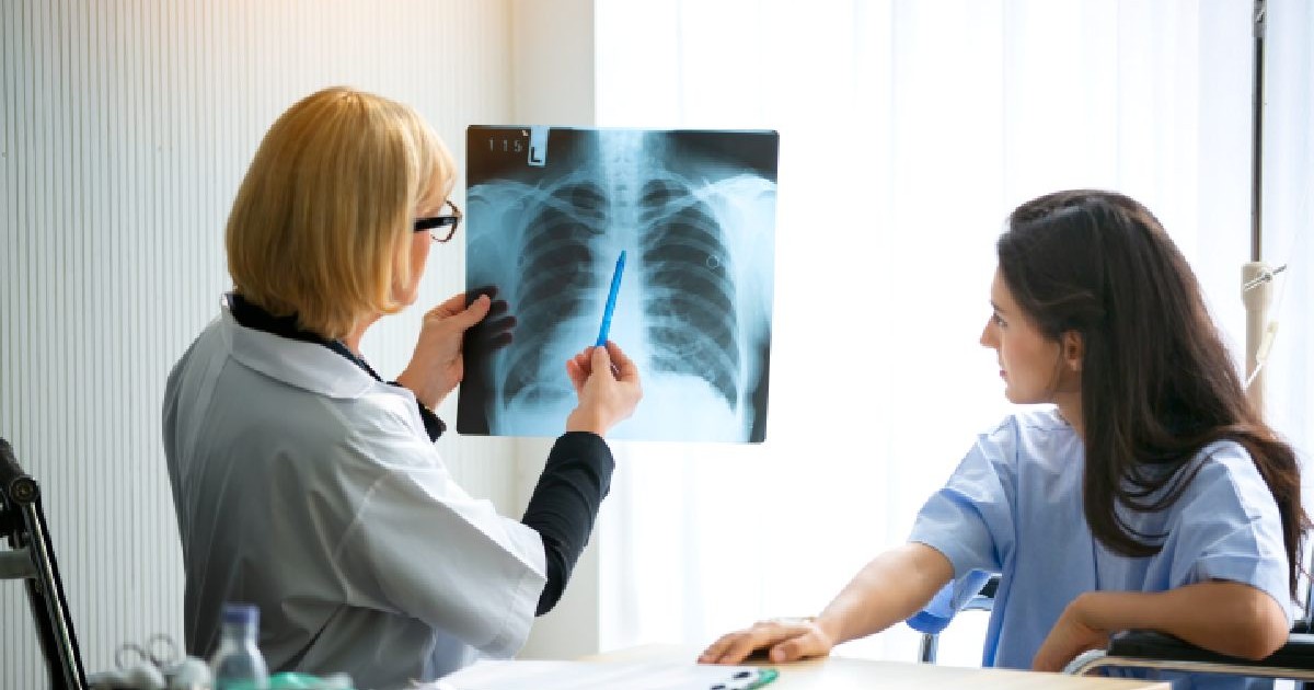 In cabinet sta un medic, o femeie blonda in halat, si priveste catre o radiografie pulmonara si o femeie, pacienta priveste catre radiografie. Românii care suferă de o boală pulmonară gravă habar nu au că sunt bolnavi