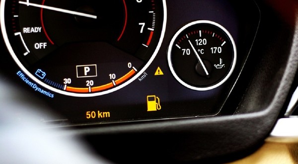 Martorul de combustibil aprins pe bordul unei mașini, indicând o autonomie rămasă de 50 km.
