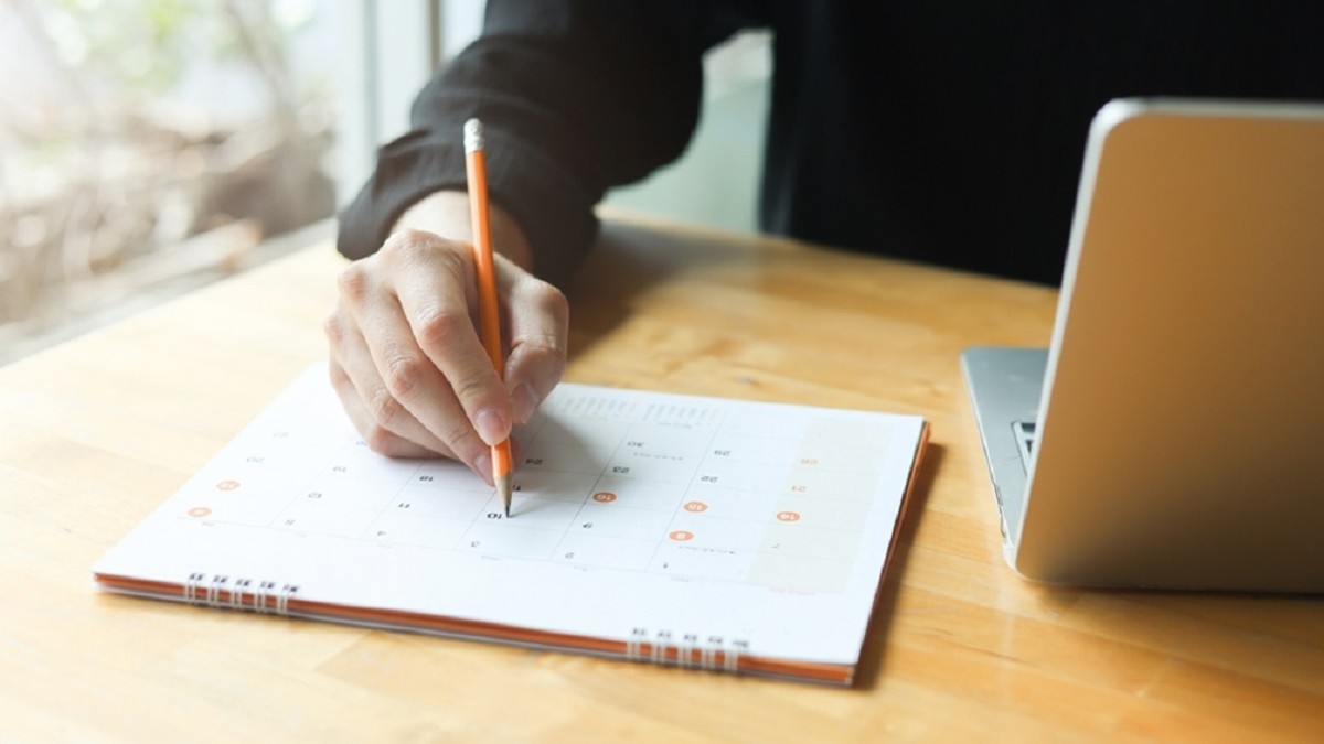 Zile libere 2026 – Câte libere sunt anul viitor - Imagine cu un bărbat care notează ceva în calendar