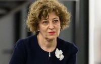 Oana Gheorghiu, îmbrăcată într-un costum negru, în timpul unei conferințe 
