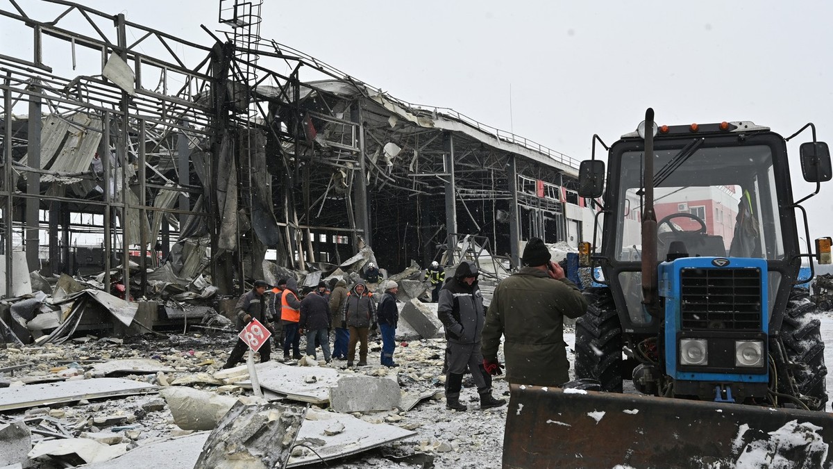Echipele de salvare ucrainene curăță molozul de la terminalul companiei poștale Nova Poshta, grav avariat în urma unui atac aerian în Novyi Korotych, regiunea Harkov, pe 13 ianuarie 2026, în contextul invaziei rusești în Ucraina.