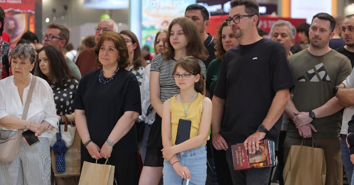 Mai mulți oameni, cu cărți în mână sau pungi Litera, participă la lansarea cărții Gutenberg 42, la Bookfest