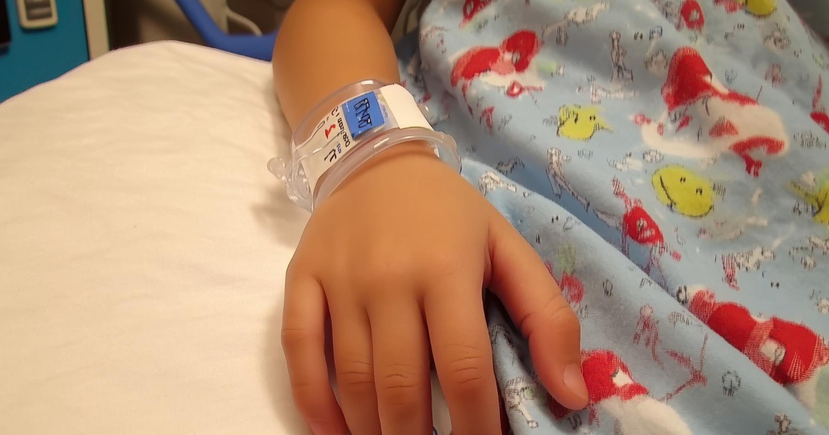 foto copil cu banderolă de spital la mână