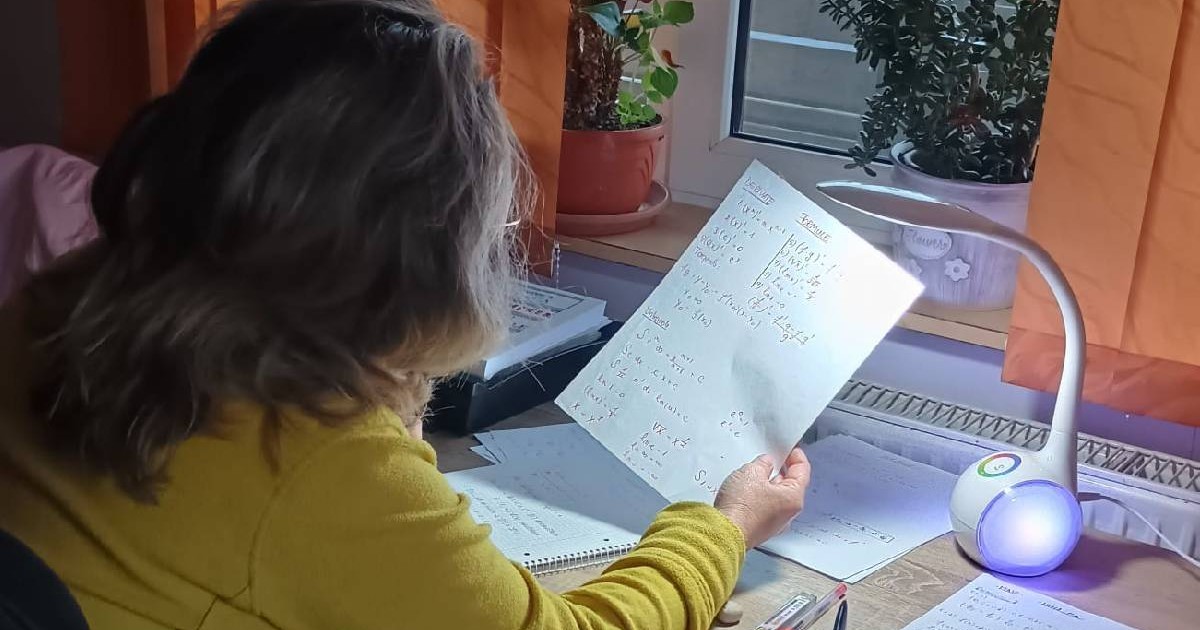 Femeia care stă la biroi și învață și citește un text de pe o foaie