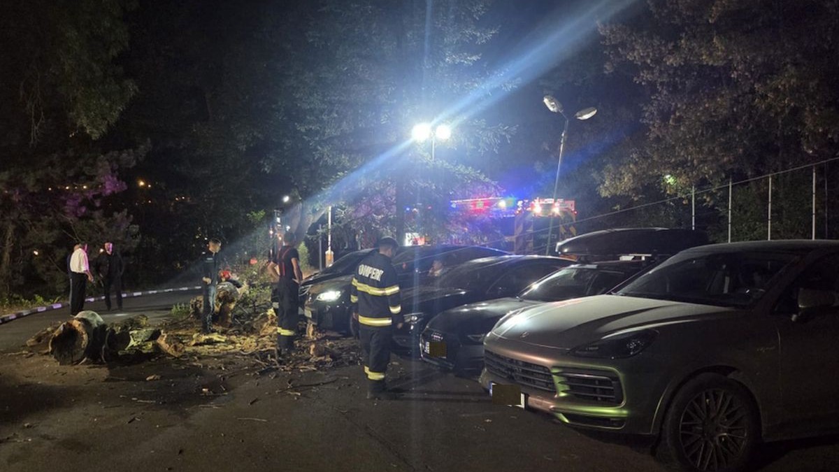 Un copac a căzut noaptea peste patru mașini negre, de lux, aflate în parcarea unui restaurant, iar poliția și pompierii sunt la fața locului, Parcul Herăstrău, București, 12 septembrie 2025