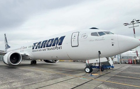 O aeronavă albă TAROM (cu numele de botez „Ivan Patzaichin” inscripționat în partea din față) staționată pe pista unui aeroport.