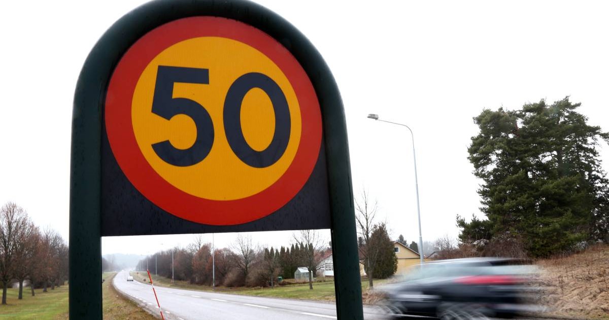 indicator limitare viteza 50 km/h pe un drum cu o banda pe sens, se observa o masina neagra care trece cu viteza