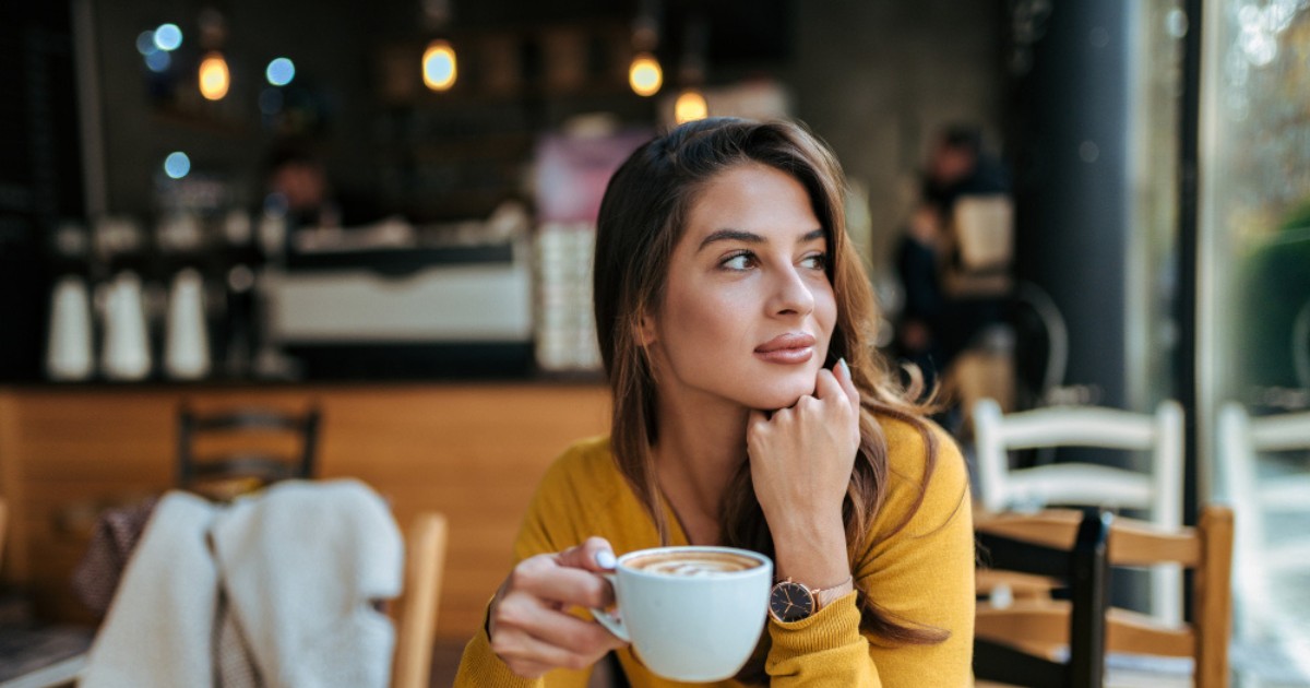 o femeie bea dintr-o ceașcă de cafea