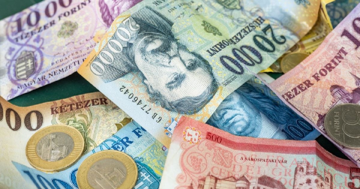 Imaginea prezintă o vedere de aproape a mai multor bancnote și monede maghiare (forinți) de diverse cupiuri, împrăștiate dezordonat.