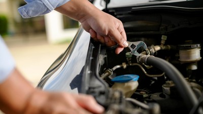 Un șofer remediază singur o problemă minoră la motor_123rf