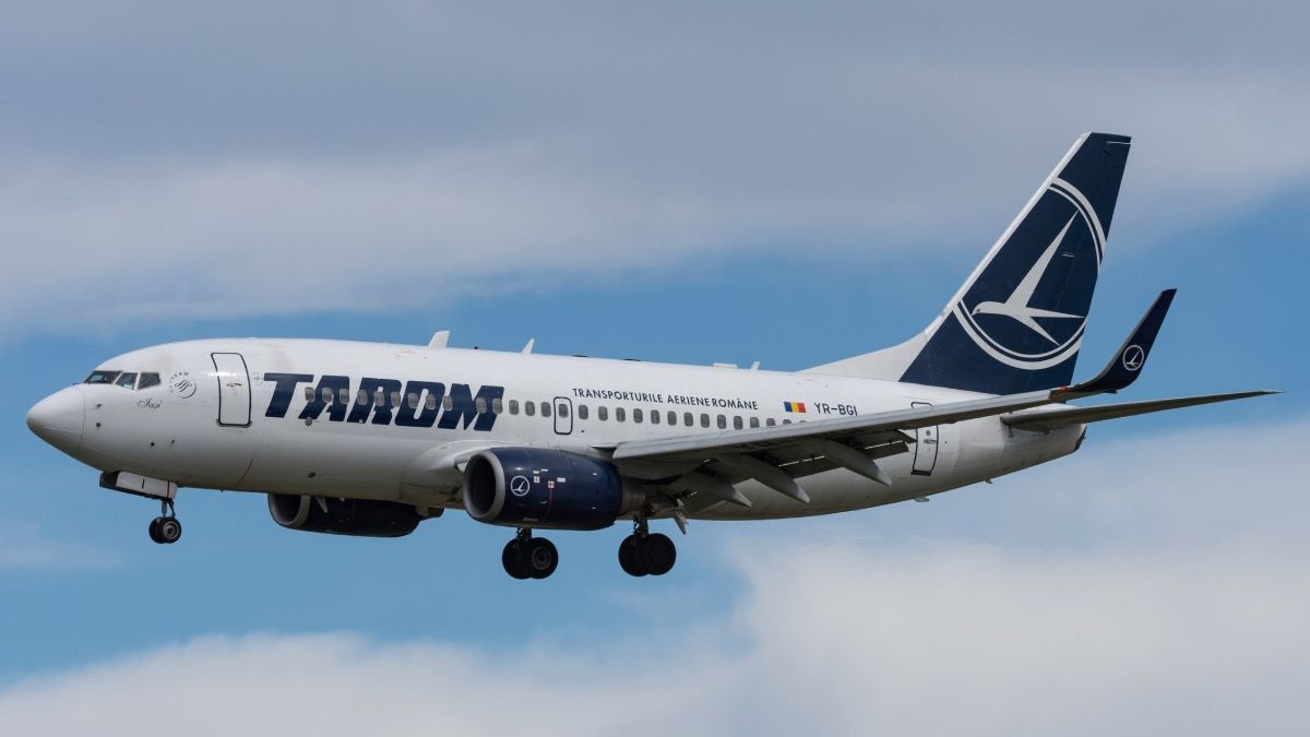 Avion Boeing 737 aparținând TAROM, aflat în zbor, cu cerul senin pe fundal
