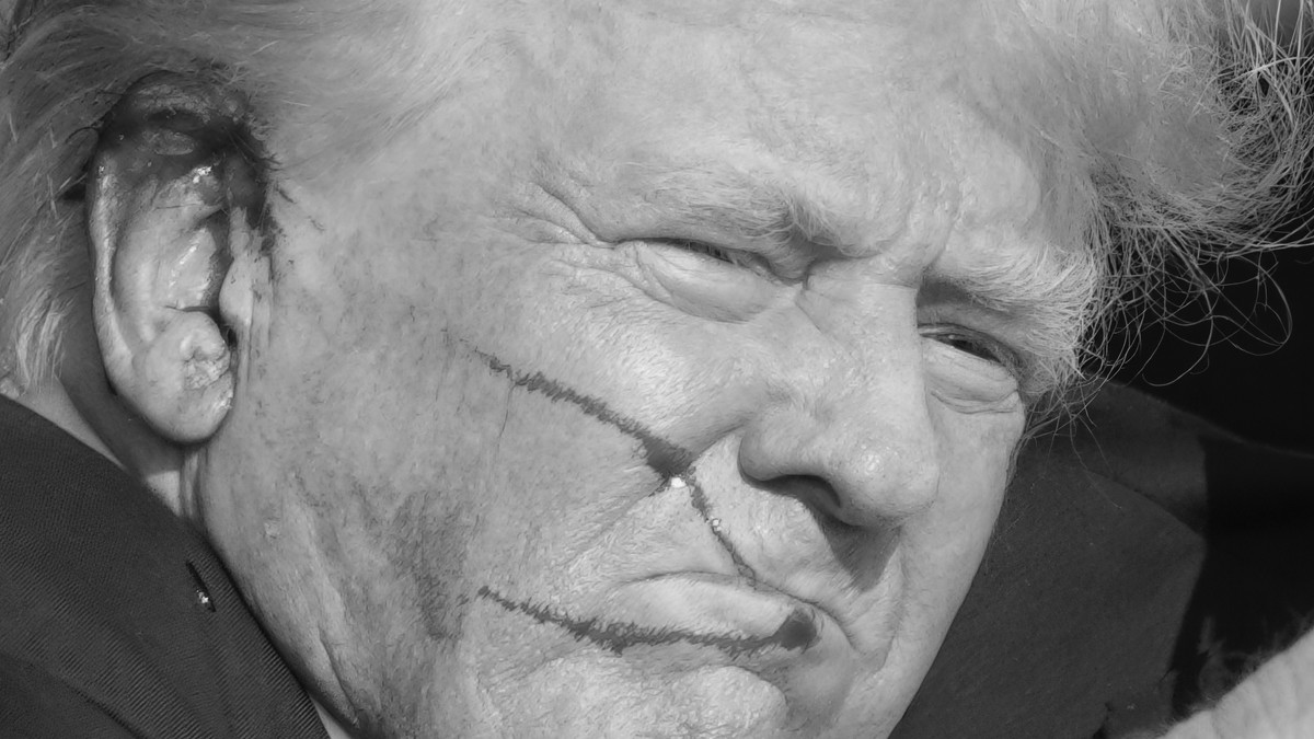 Donald Trump, imediat după ce a fost lovit de un glonț în ureche, cu sânge pe față Foto Profimedia
