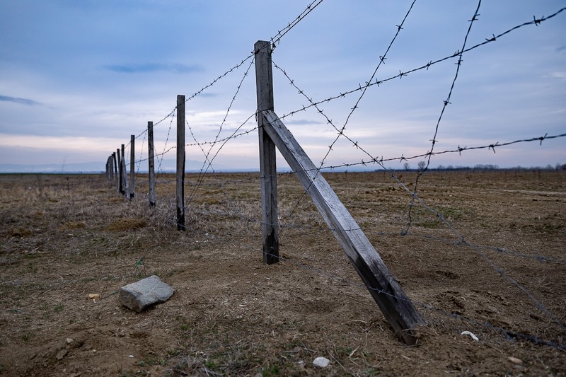 Un pilon al gardului e sprijinit cu o sârmă legată de un bolovan