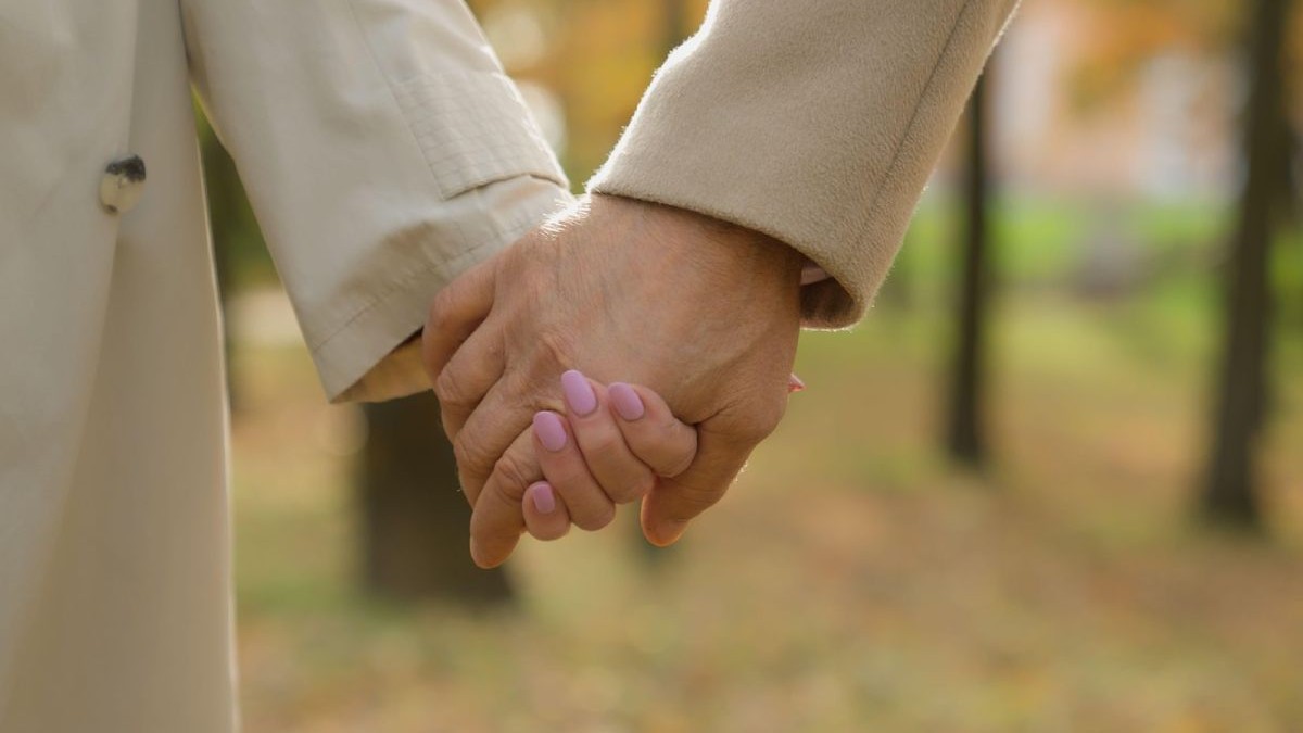 Imagine creativă cu un bărbat și o femeie care se țin de mână, prim plan, într-un parc