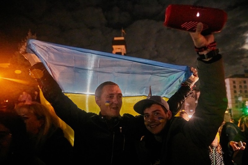 Doi tineri sărbătoresc eliberarea Hersonului, în Piața Independenței din Kiev, pe 11 noiembrie 2022. | Foto: Profimedia