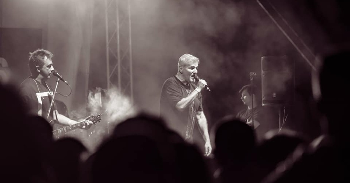 Trupa Holograf donează banii primiți pentru spectacolul din Sectorul 5. Fotografie alb-negru din timpul unui concert al trupei Holograf, cu Dan Bittman la microfon