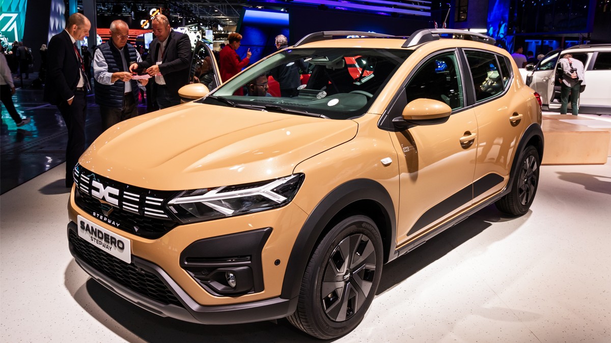 O Dacia Sandero la o expoziție de mașini este analizată de posibili clienți.