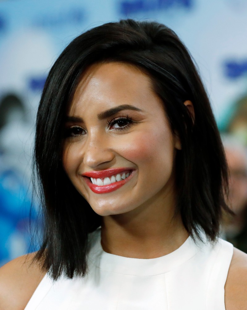 epa05857097 US singer/actress Demi Lovato smiles at the International Day of Happiness in conjunction with 'Smurfs: The Lost Village' event at United Nations headquarters in New York, New York, USA, 18 March 2017. Lovato is the dubbing voice of the character 'Smurfette' in the upcoming movie 'Smurfs: The Lost Village'. EPA/JASON SZENES