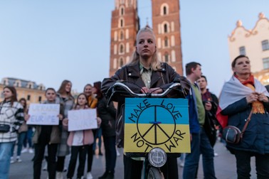 „Faceți dragoste, nu război”, scrie fata cu bicicletă din piață