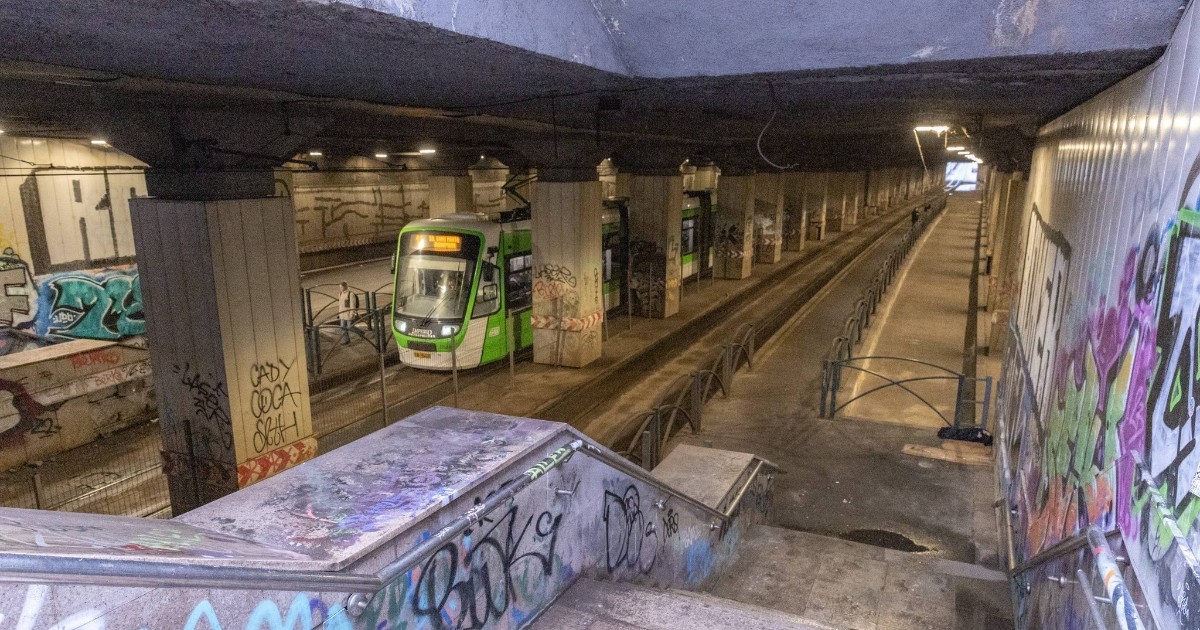 Imaginea surprinde un pasaj subteran cu aspect degradat, marcat de graffiti și pereți deteriorați. În interior se vede un tramvai care traversează zona, evidențiind utilizarea intensă a infrastructurii în ciuda stării precare.