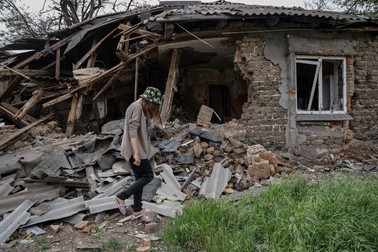 O femeie trece pe lângă casa ei distrusă din Mariupol, Ucraina, 21 mai 2022. Potrivit șefului autoproclamatei Republici Populare Donețk, Denis Pușilin, 60 la sută din casele din Mariupol au fost distruse, dintre care 20 la sută nu pot fi reconstruite. Foto: EPA