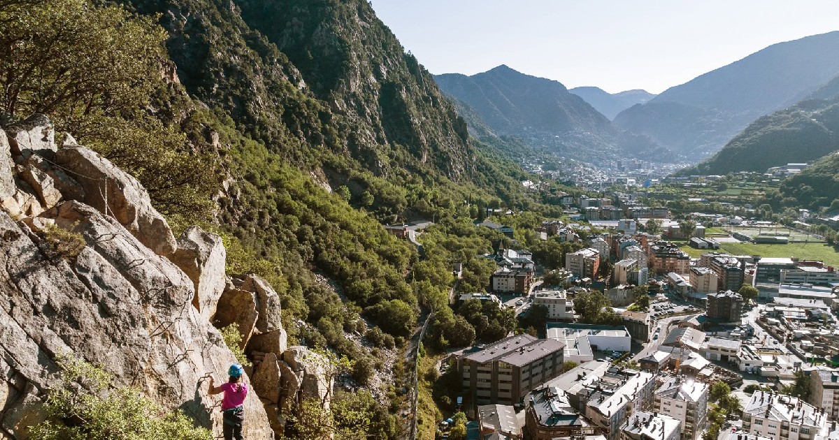 O persoană se cațără pe un munte în apropierea unui oraș din Andorra