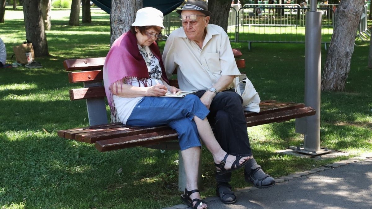 Un cuplu de pensionari stă pe o bancă în parc. Foto: Libertatea/ Dumitru Angelescu