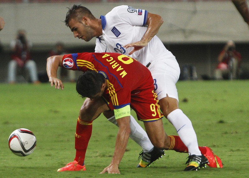 epa04390052 Panagiotis Tachtsidis (R) of Greece in action against Ciprian Marica (L) of Romania during the UEFA EURO 2016 qualifying Group F soccer match between Greece and Romania at Karaiskaki stadium in Piraeus near Athens, Greece, 07 September 2014. EPA/YANNIS KOLESIDIS