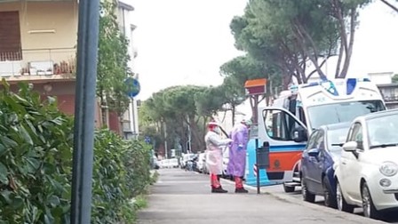Un echipaj medical de pe ambulanță își pregătește costumele de protecție pentru a putea prelua un bolnav cu COVID-19