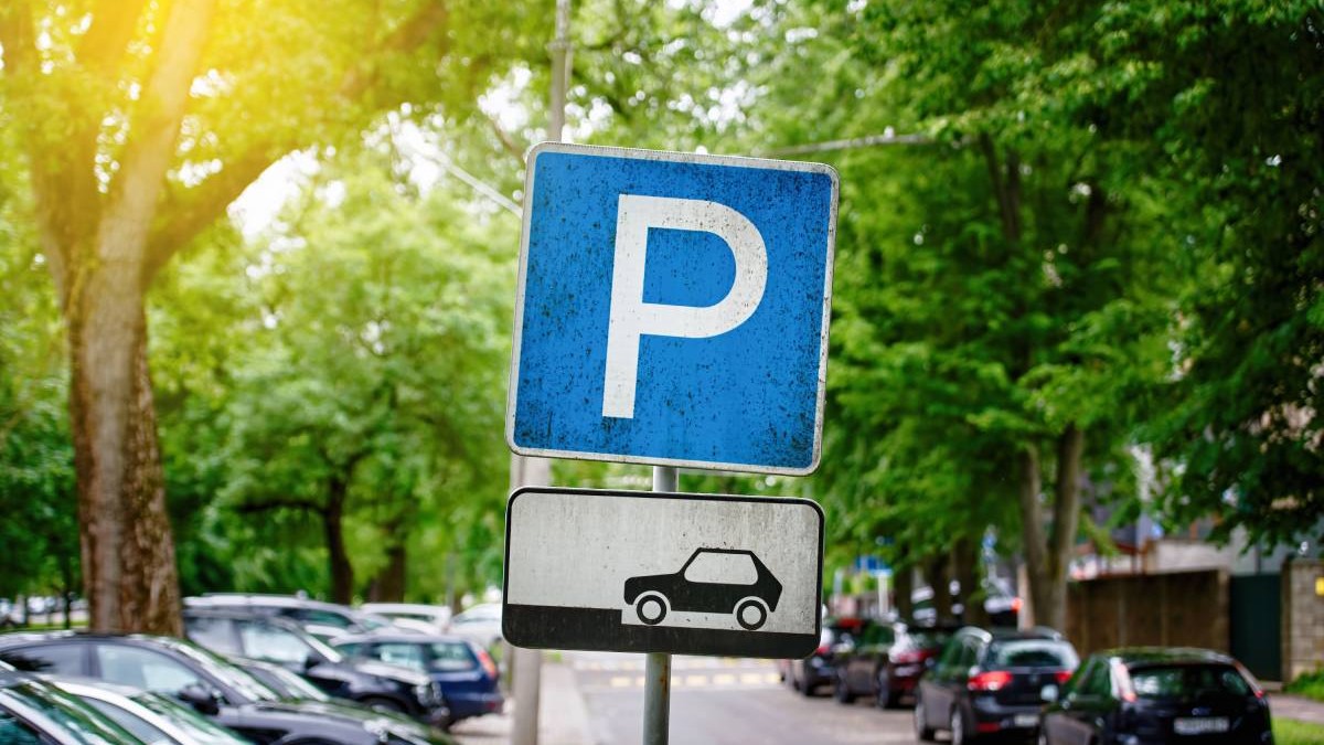 Indicator de parcare, mașini parcate sub copaci verzi în zonă rezidențială, Zonă de parcare.