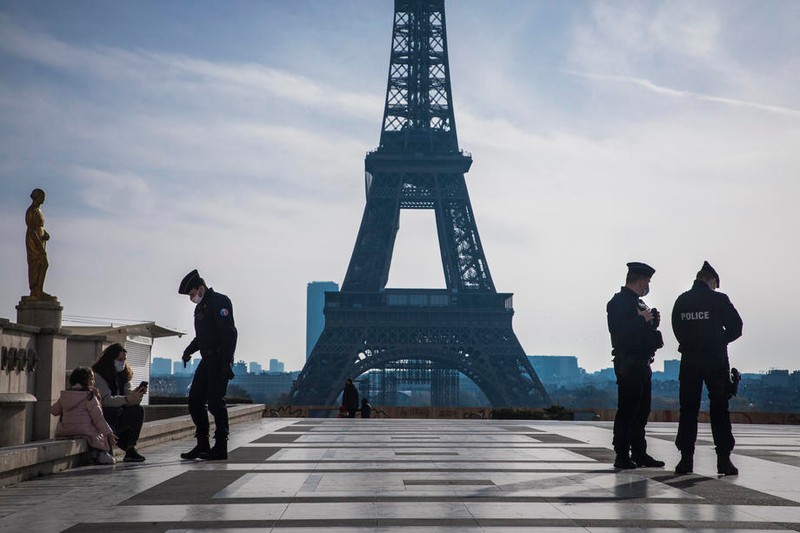 Polițiștii francezi controlează declarația pe proprie răspundere, în piața pustie Trocadero, lângă Turnul Eiffel, în timpul celui de-al doilea blocaj național | Foto: EPA