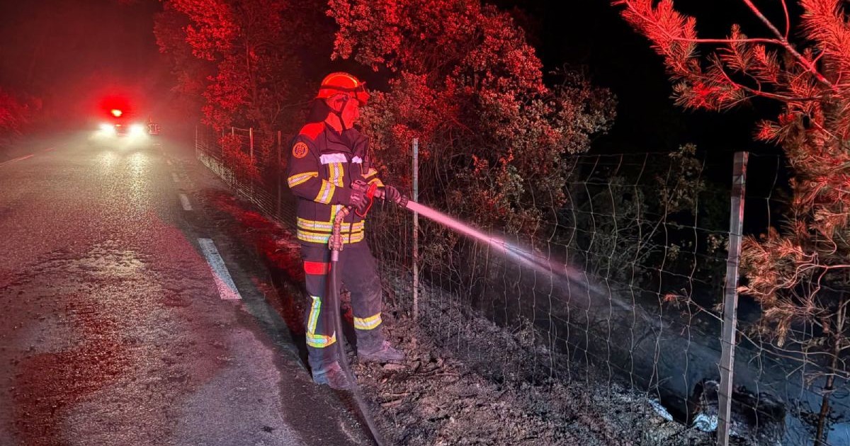 Pompier român, îmbrăcat în echipamentul de serviciu, cu cască roșie, ține în mână un furtun cu care stinge un incendiu, în Franța, în iulie 2026
