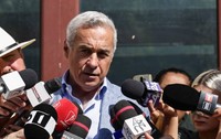 Călin Georgescu vorbește cu jurnaliștii la ieșirea din Parchet. e îmbrăcat cu un costum și are o figură gravă