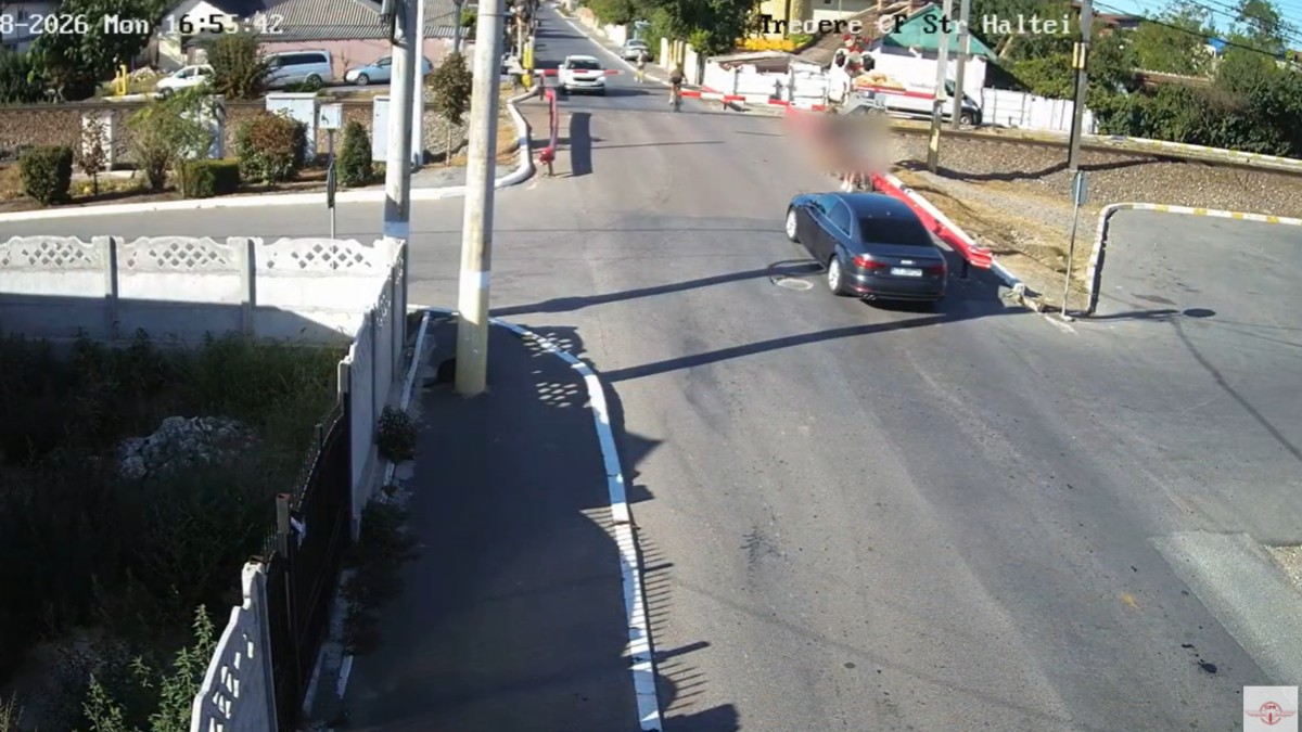 Imagine de pe camera de supraveghere cu copii pe biciclete care traversează calea ferată
