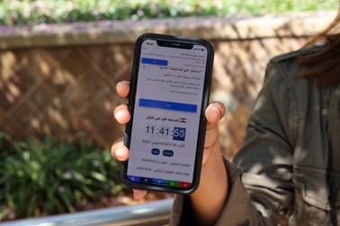 A woman in Beirut holds a mobile telephone showing contradicting time zones on March 26, 2023, after Lebanon's government announced a decision to delay daylight savings. The caretaker government announced on March 23 its decision to delay rolling clocks forward until April 20, instead of the last week of March as is usually the case in Lebanon and much of the northern hemisphere.,Image: 765268849, License: Rights-managed, Restrictions: , Model Release: no