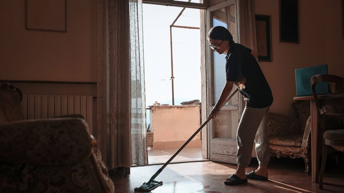 O femeie dă cu mopul prin cameră, ianuarie 2026