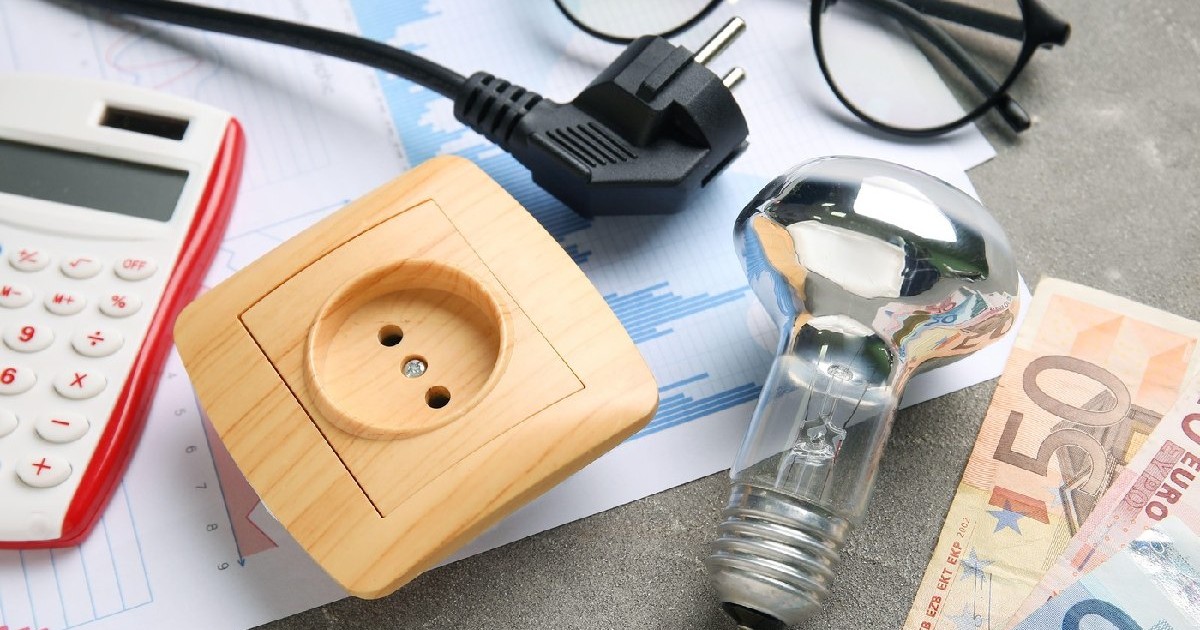 Priză electrică și priză cu bec, calculator și bani pe fundal