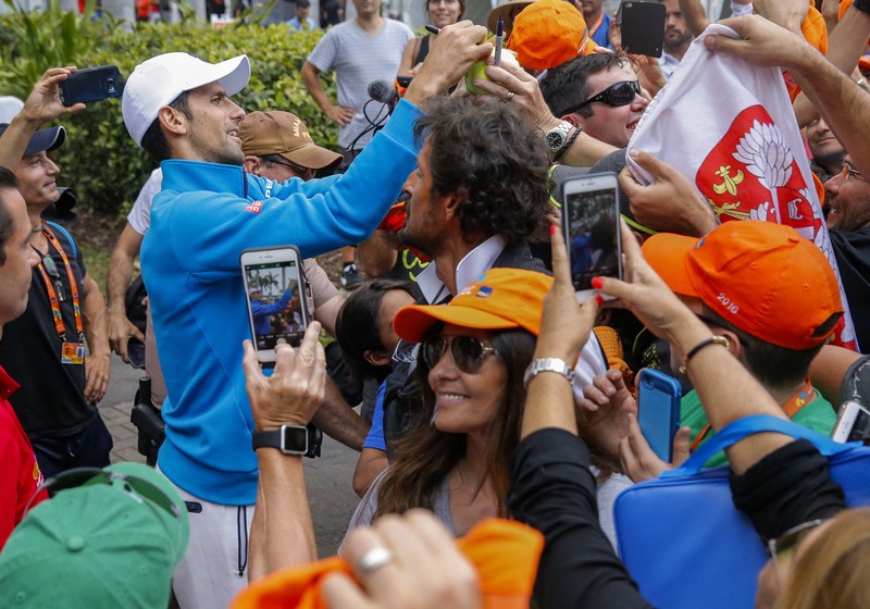 epa05242881 Novak Djokovic of Serbia signs autographs for fans after defeating Kei Nishikori of Japan during in men's singles final match at the Miami Open tennis tournament on Key Biscayne, Miami, Florida, USA, 03 April 2016. EPA/ERIK S. LESSER