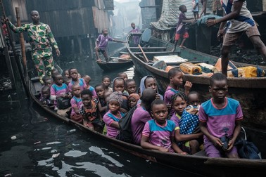 A picture taken on March 1, 2019 shows a teacher (L) picking up his students in a boat from their homes and taking them to their private school in the Makoko waterfront community in a polluted lagoon in Lagos, Africa’s biggest megalopolis in Nigeria. The sprawling community began in the 19th century as a fishing village for immigrants who settled on the water's edge. As more arrived and land became rare, people started to move out onto the water. Over time, Makoko became a floating realm of perhaps a quarter of a million people, although the real number is anyone's guess.,Image: 493065587, License: Rights-managed, Restrictions: , Model Release: no, Credit line: Profimedia