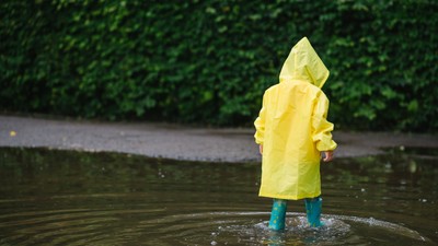 copil în ploaie cu pelerină galbenă