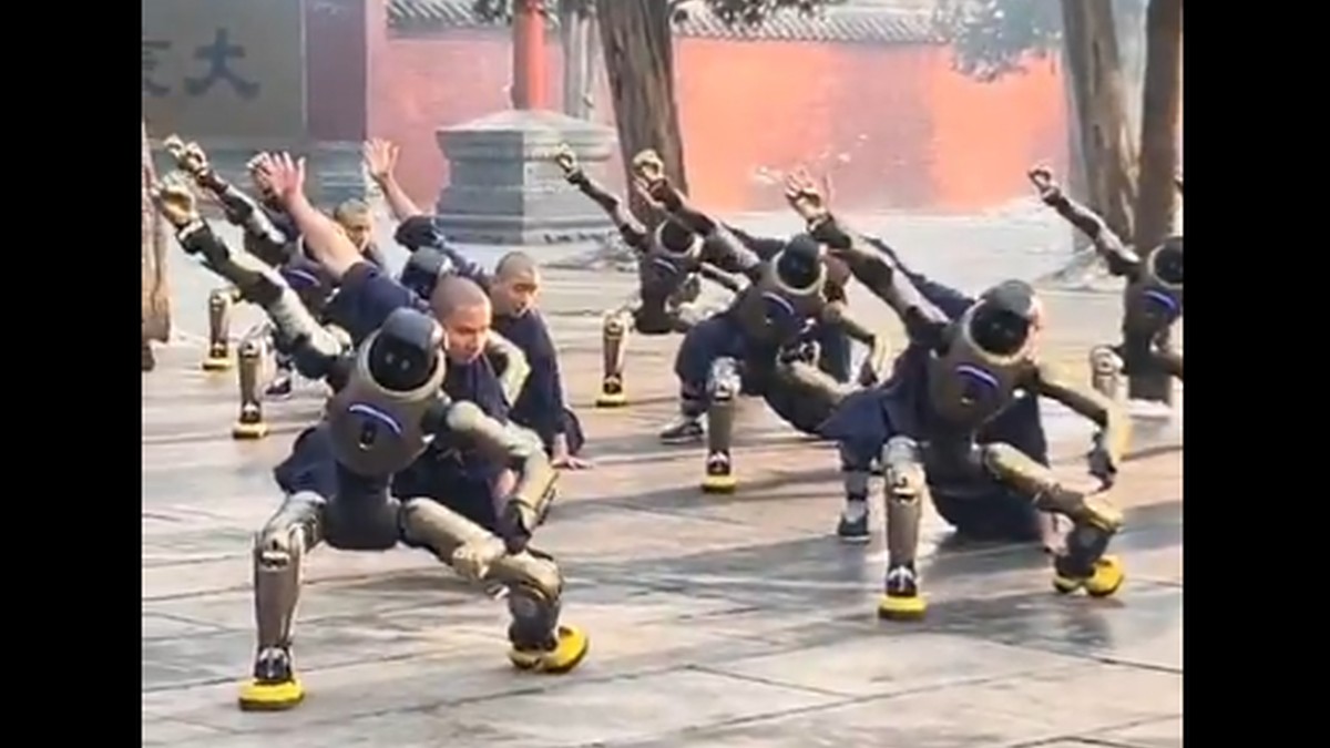 Mai mulți roboți fac mișcări de kung fu alături de călugări Shaolin