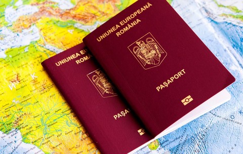 Diferența dintre pașaport simplu electronic și simplu temporar - Imagine cu două paşapoarte româneşti pe o hartă