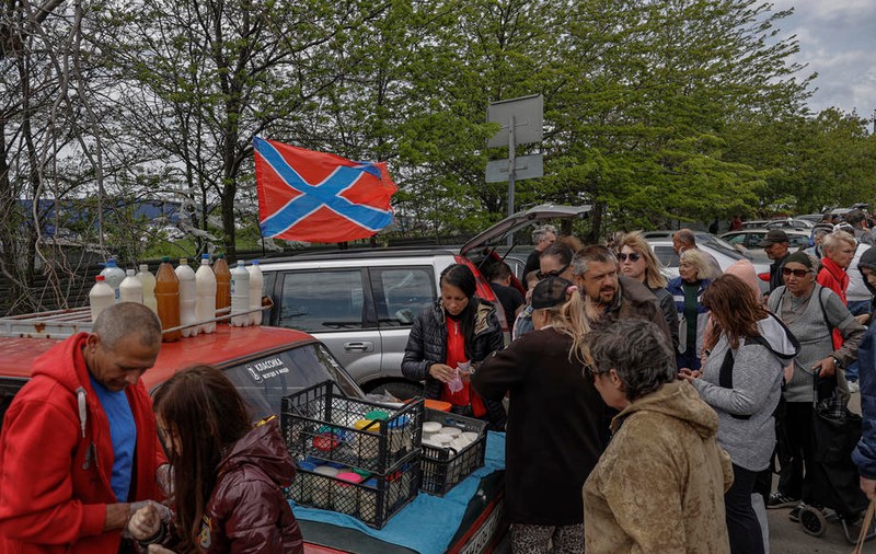 Locuitorii rămași în Mariupol stau la cozi pentru a primi pachete mici cu mâncare. Unii leșină așteptând