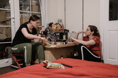 Ella și Crina iau cina. Pentru că n-au terminat încă de renovat bucătăria, mănâncă într-un colț din living. Tamworth, UK, august 2021