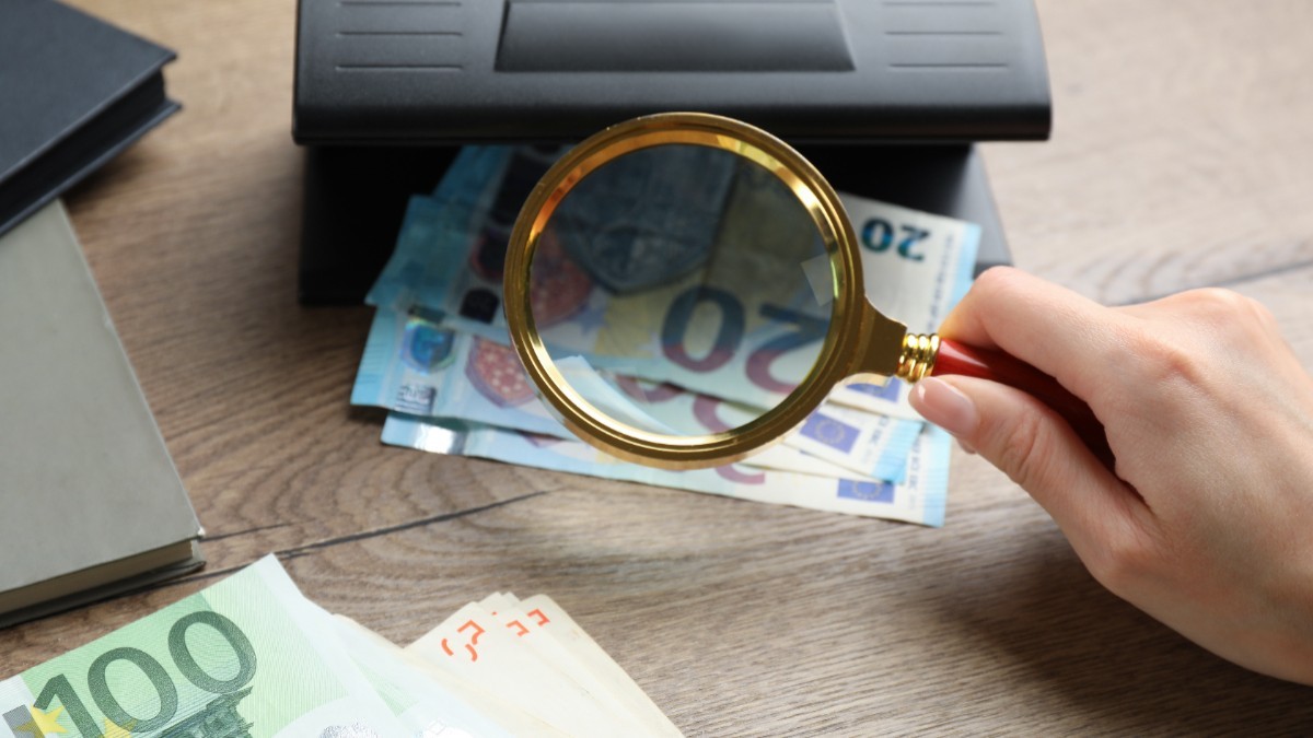 Femeie verificând bancnotele euro 